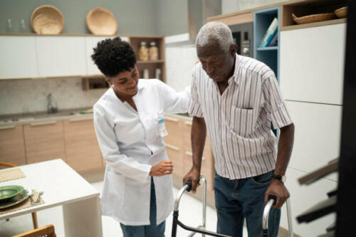 Caretaker assisting senior man with walker