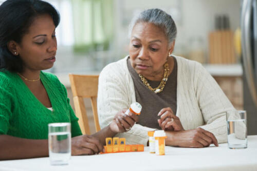 daughter assisting and explaining medicines to mother